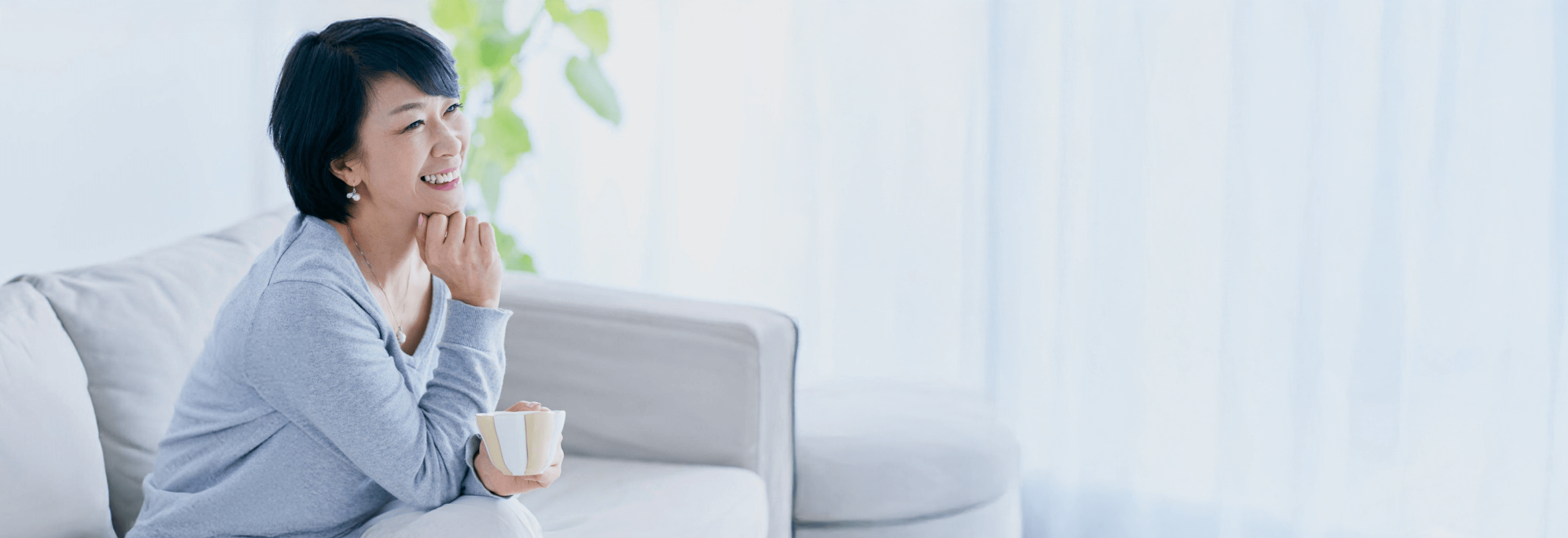 Người phụ nữ trung niên mỉm cười thư thái trên sofa